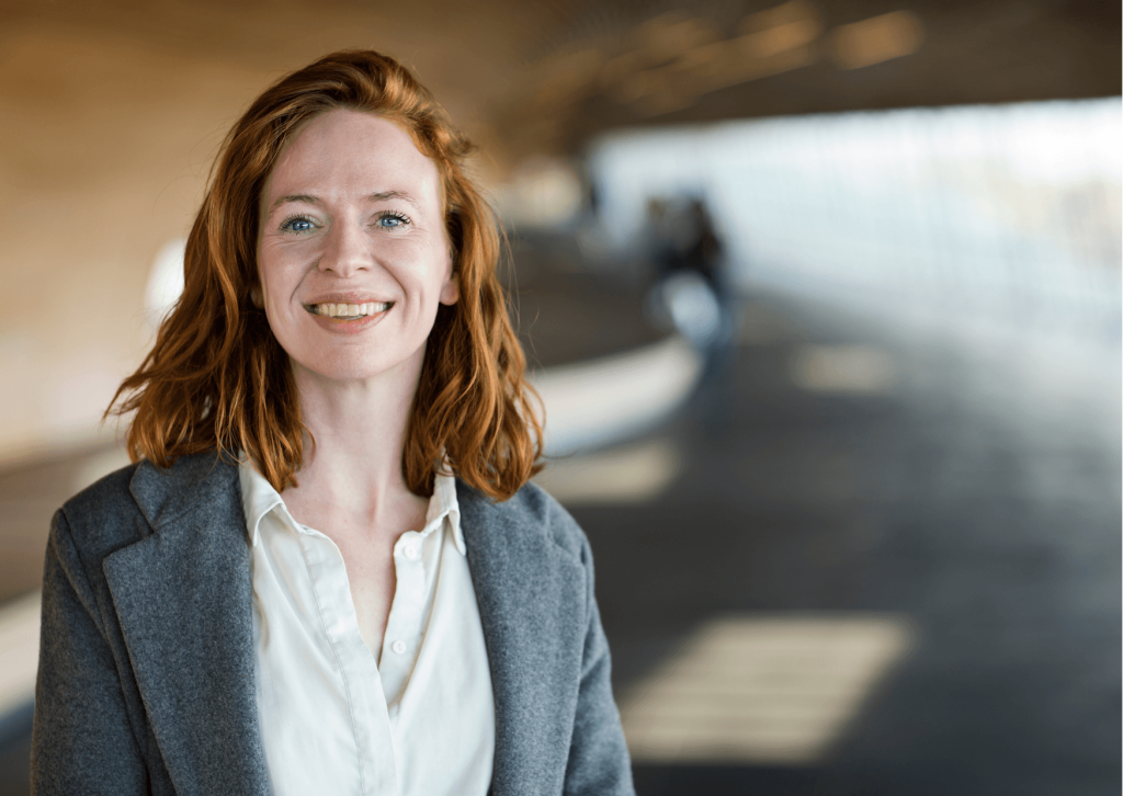 Disability Tech Ambassador, Cathrine Mejdal, is smiling at the camera. Her mission is to "promote co-creation, knowledge exchange and counteract technoableism, so that we create solutions that empower us – not eliminate us."